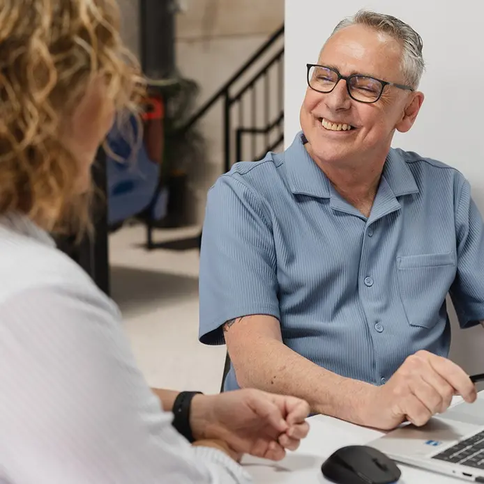 Smiling Darren looking at a client who has her back to the camera.
